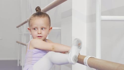 Little Girl Stretching at Ballet Barre in Dance Studio
