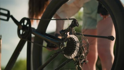 Woman Spinning Bike Tire Outdoors on Sunny Day