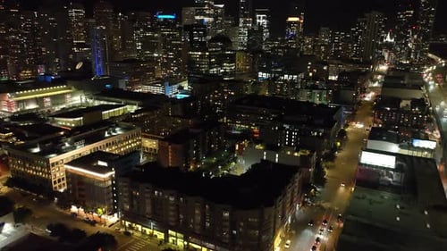 Vista de gran ángulo de las calles y las ofertas en la ciudad nocturna, inclinada hacia arriba, revelación del horizonte con iluminación