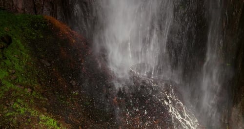 Gros plan puissant d'une brume de cascade sur des falaises moussues