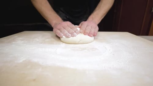 Hands Kneading Dough on Wooden Surface