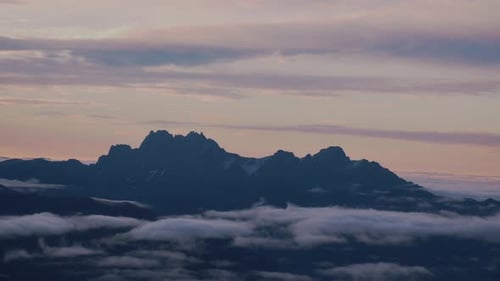 Mountain Peaks Silhouetted Above the Clouds at Sunset