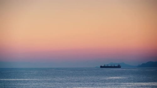 Sea At Evening With Cargo Ship On Horizon