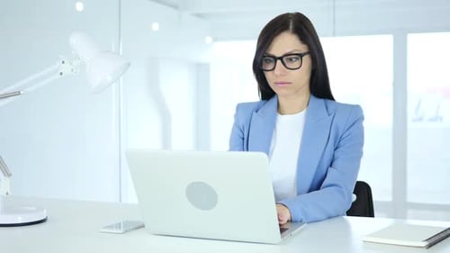 Woman Typing on Laptop in Bright, White Office