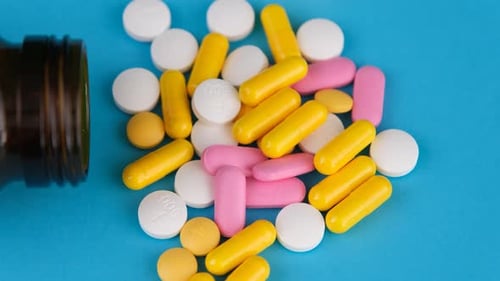 Pills and Capsules Spill out of Medicine Bottle