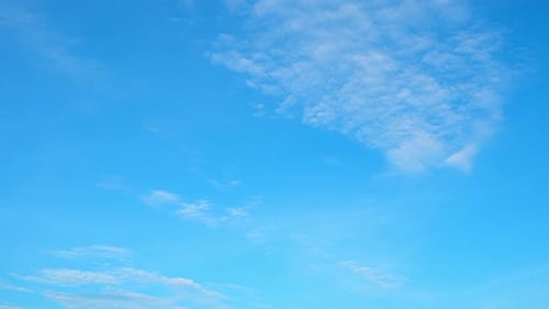 Clouds Float serenely across Blue Sky on Sunny Day