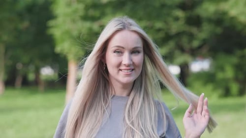 Smiling Blonde Woman Posing in Park