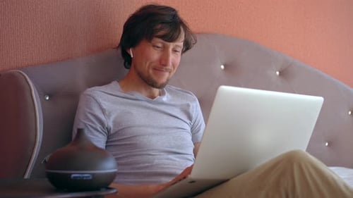 Young Man Relaxing at Home with Laptop