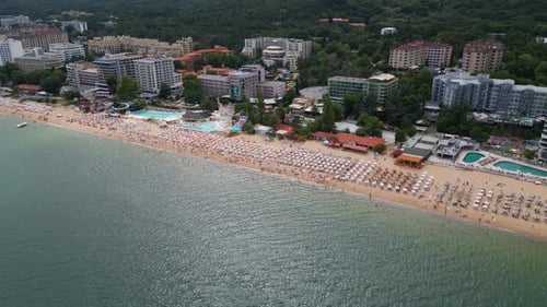 Aerial View of a Picturesque Beach Lined with Umbrellas and People Enjoying a Sunny Day By the Sea