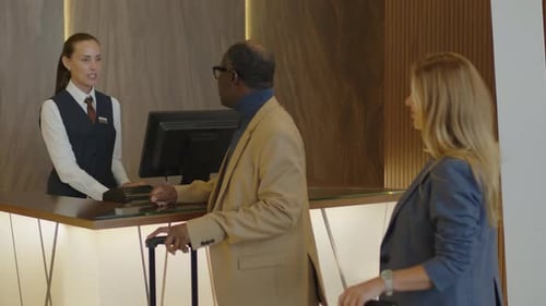 Man Giving Passport to Hotel Manager at Check-In Desk