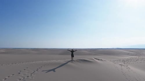 Aerial View of a Solitary Figure Standing on Sand Dunes in Yemen's Desert Landscape