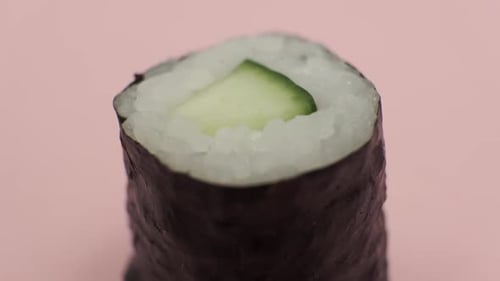 Sushi roll rotating on rosy background
