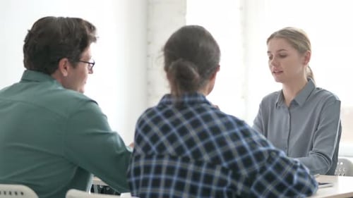 Young Blonde Woman Talking with Customers in Office