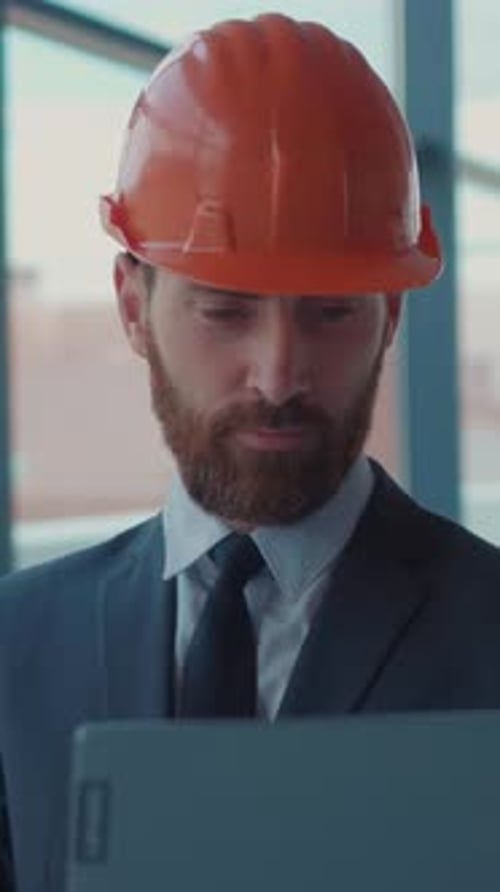 A Businessman Wearing a Hard Hat on a Worksite Focusing on the Construction Project at Hand