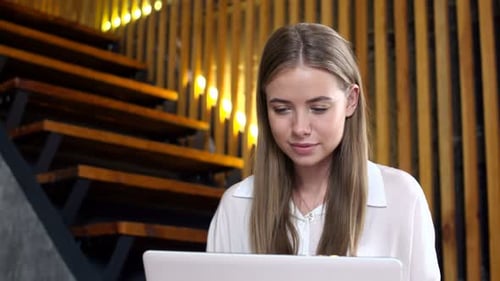 Woman Using Laptop in Modern Office Setting
