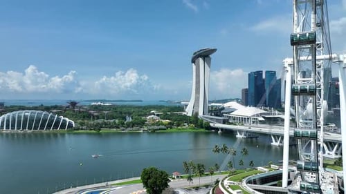 Drone orbiting shot of Singapore Flyer Eye, Marina Promenade, with Marina Bay Sands and Singapore an