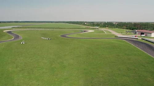 Aerial Shot of Sports Car Racing on Professional Race Track, Sunny Day 4k