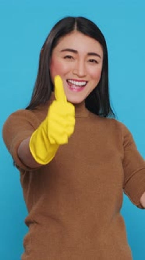 Young Woman Giving Thumbs Up with Cleaning Glove