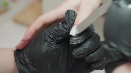 Manicurist files nails in beauty salon, nail care
