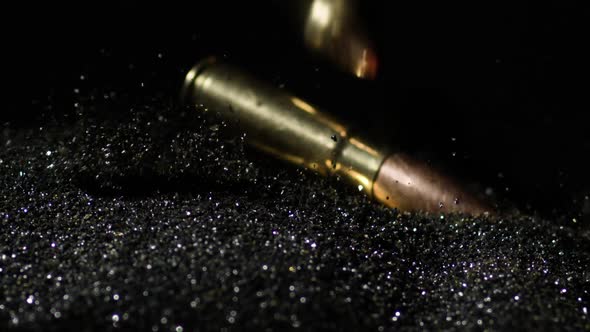 Slow motion shot of cartridge firearms bullets falling on gunpowder ...
