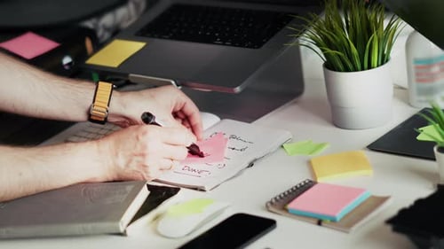 Hand placing DONE sticky note completed task checklist