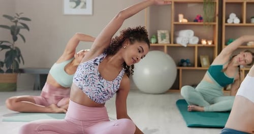 Women Stretching and Practicing Yoga in Bright Studio
