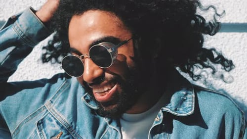 Smiling Man with Curly Hair and Sunglasses