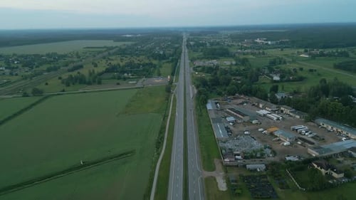 Aerial View of a Calm Highway and Serene Countryside During Sunset Showcases a Tranquil Rural