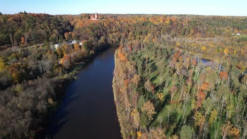 Aerial view of a tranquil river surrounded by autumn foliage
