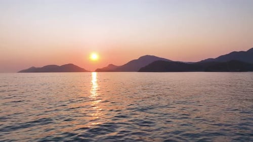 Golden Sun Slowly Descends Below Horizon Casting Warm Glow Across Tranquil Ocean Waters and Painting