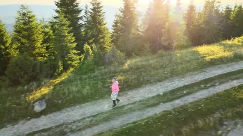Young Jogger Trail Running on Wild Mountain Footpath While Camping Alone at Beautiful Sunrise