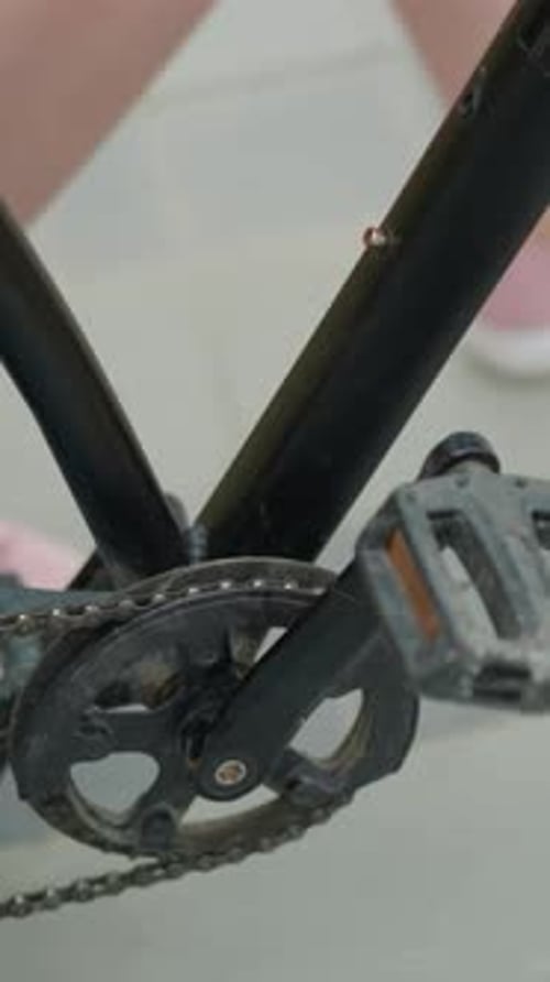 CloseUp of Bicycle Pedal and Person in Pink Sneakers on Paved Path
