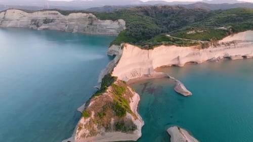 Cinematic aerial view of Cape Drastis's white cliffs and hidden beaches in Corfu, Greece