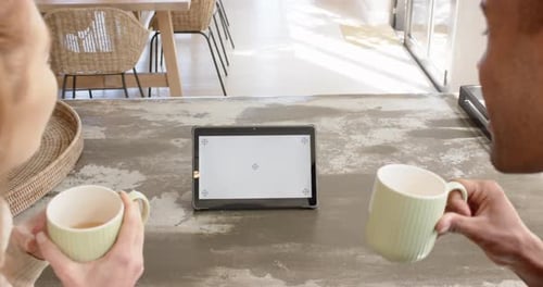 Couple Drinking Coffee Looking at Blank Tablet Screen