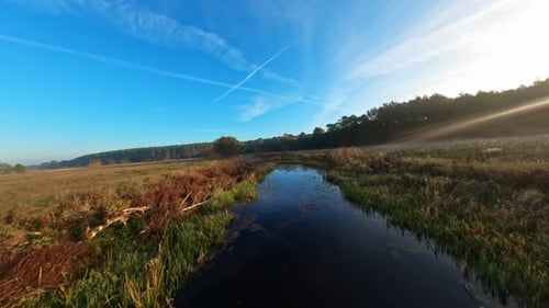 Drone Flying Over Water And Meadow