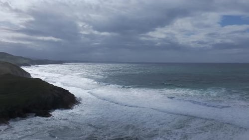 Aerial orbit over the turquoise Cantabrian Sea and rocky cliffs