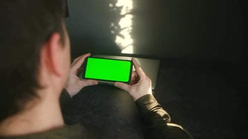 Man Holding Smartphone with Green Screen Mockup