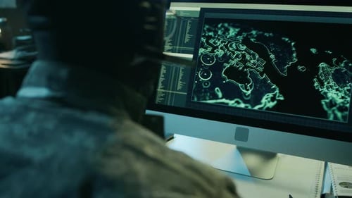 Soldier in Uniform Works at a Computer Station