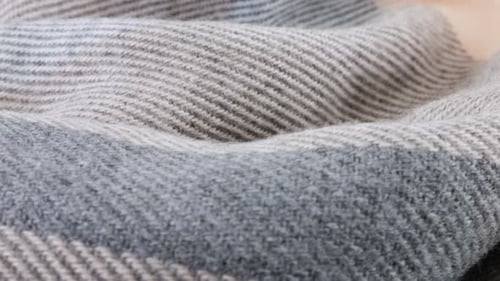 Close-up view of the soft folds of wool fabric in pastel gray-pink colors rotated