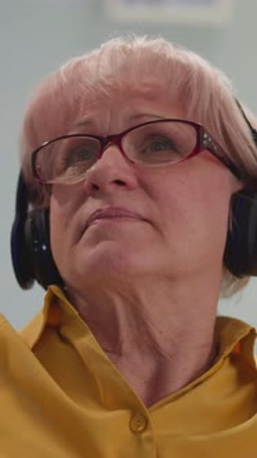 Senior Woman Listening Attentively with Headphones