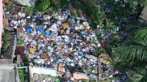 Aerial, large pile of trash bags poor slum neighborhood, illegal disposal