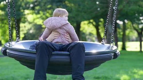 Parent and Young Child on a Saucer Swing