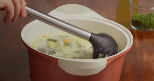 A Woman Prepares Broccoli Soup Stirs It with Creamy Broccoli Soup with Vegetables Boiling in a