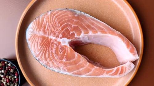 Fish, raw salmon steak, fresh seafood for grilling with salt, spices, and herbs. Raw salmon steak
