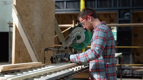 Builder Saws a Board with a Circular Saw in the Cutting a Wooden Plank