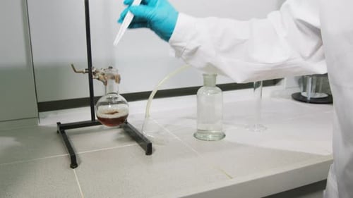 Un científico coloca un trozo de azúcar refinada en un líquido marrón para examinarlo