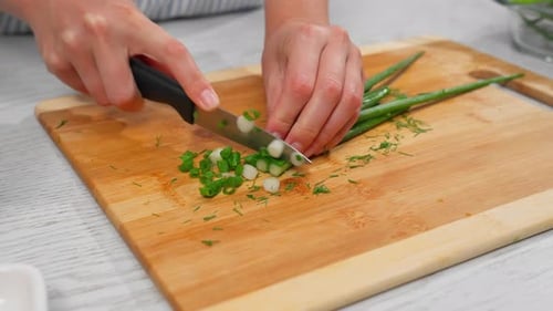 Cutting green onions in a kitchen for fresh dishes