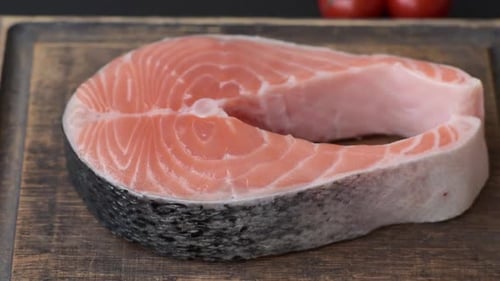 Raw Salmon Steak on Rustic Wooden Cutting Board