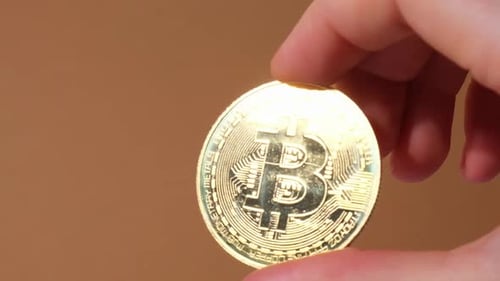 Weibliche Hände halten Bitcoin Goldmünze Bitcoin-Mining-Handelskonzept BTC Golden Money Spinning