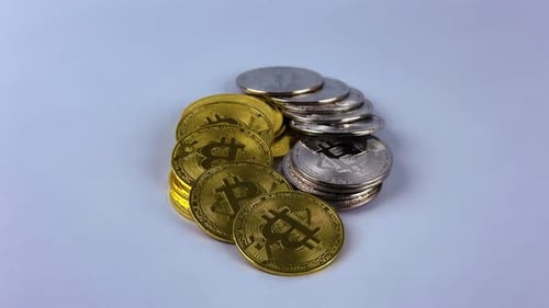 Stack of gold and silver bitcoin rotate on white surface
